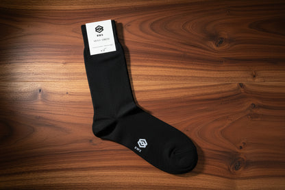 Black sock with a brand label on a wooden floor